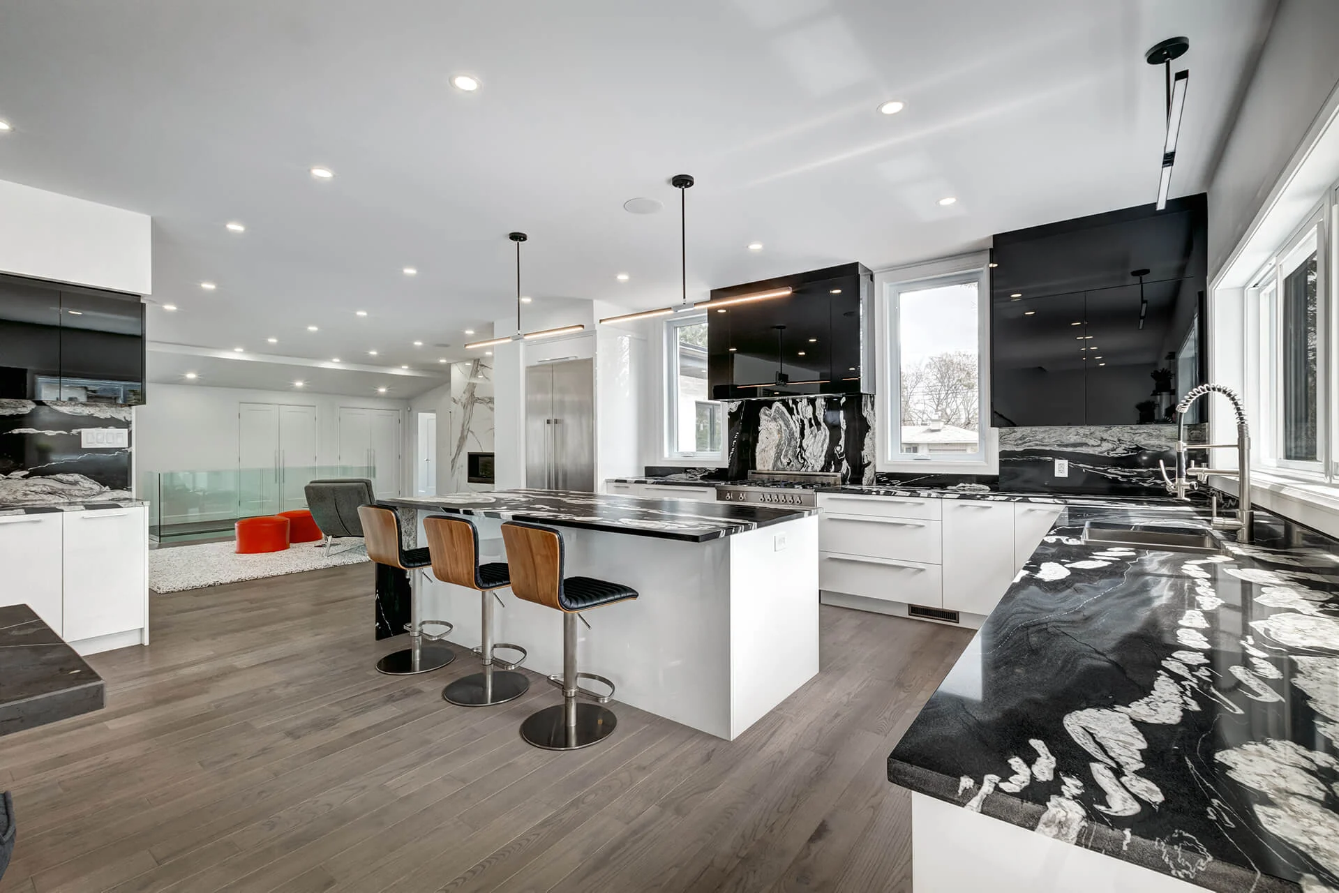 Kitchen with dramatic black-and-white stone, a slab backsplash and a waterfall island